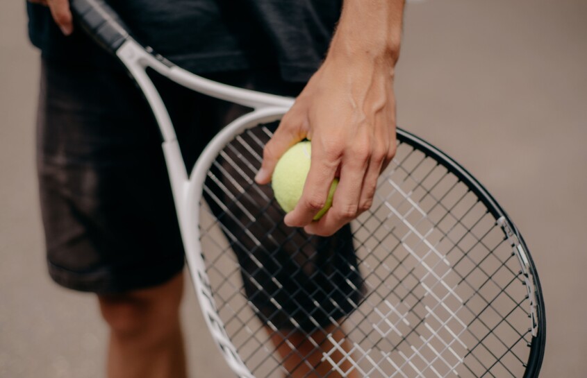 homme avec une raquette et une balle de tennis